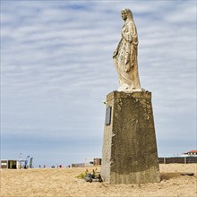 Statue of Mary on a pedestal, sculpture Notre Dame de la mer on the beach, sculptor Lucien