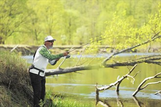 Fisherman trying to do a perfect cast, throwing lure. Spining fishing, angling, catching fish.