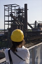 Woman on the skywalk photographing the blast furnace of the former industrial plant Phoenix West,