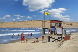 Lifeguard tower and tourists walking on the beach at Barra de Valizas, seaside resort, balneario