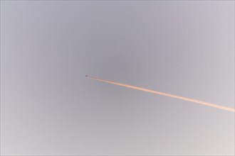 Airliners in flight in a cloudy pink and orange sky in late summer. France