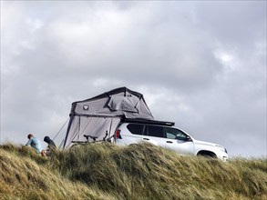 An SUV with awning stands in the dunes of a campsite, Vejers, Denmark, 16 07 2023, Europe