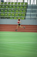 Only runner in an empty, large stadium, running track and green seats, Glaspalast, Sindelfingen