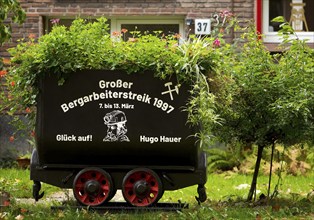 Coal lorry in the front garden commemorating the big miners' strike in 1997, Gelsenkirchen, Ruhr