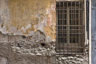 Crumbling house wall with a barred window in the old town centre, Genoa, Italy, Europe