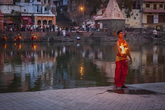 UJJAIN, INDIA, APRIL 23, 2011: Brahmin performing Aarti pooja ceremony on bank of holy river