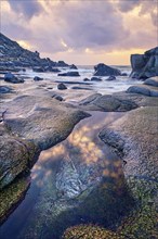 Rocks on beach of fjord of Norwegian sea in winteron sunset. Utakliev beach, Lofoten islands,