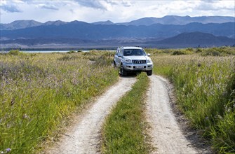 A Toyota Landcruiser off-road vehicle on a dirt track, Yssykköl, Kyrgyzstan, Asia