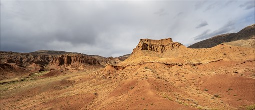 Eroded mountain landscape with sandstone cliffs, red and orange rock formations, Konorchek Canyon,