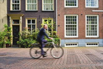 Motion blurred bicycle rider cyclist man on bicycle very popular means of transport in Netherlands