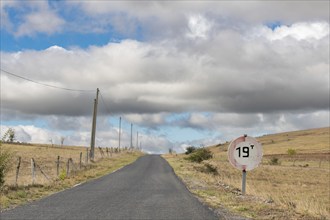 Desolate road in the countryside on a sunny summer day. Cevennes, France, Europe