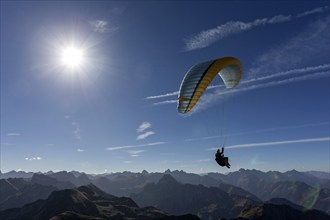 Paragliders on the Nebelhorn, mountains of the Allgäu Alps in the background, backlight,