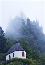 Plague Chapel St. Rochus and Reichsburg Castle in the fog in the early morning, Cochem,