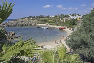 Italian tourists swimming and sunbathing on sandy beach in summer along the Ionian Sea in the