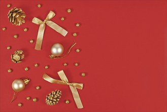 Christmas flat lay with elegant golden ornaments like tree baubles, painted pine cones and ribbons