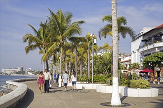 Mexican tourists walking along the Malecón, esplanade in city Puerto Vallarta, beach resort on the