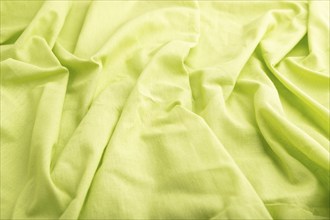 Fragment of green linen tissue. Side view, natural textile background and texture. wave concept,