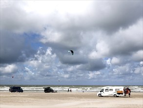 Motorhomes standing on Vejers beach in the North Sea, sail of a kite surfer, Vejers, Denmark, 17.07