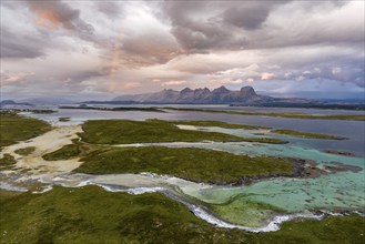 View of mountain range Seven Sisters from Herøy island, light mood with rainbow, Helgeland coast,