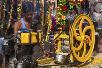 PUSHKAR, INDIA, NOVEMBER 20, 2012: Street vendor makes sugarcane juice by crushing peeled sugar