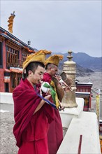 THIKSEY, INDIA, SEPTEMBER 4, 2011: Two Tibetan Buddhist monks blowing conches during morning pooja,