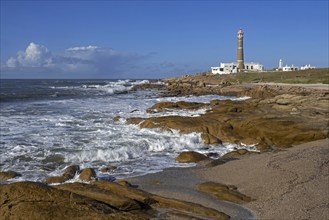 Rocky shore and lighthouse at Cabo Polonio along the Atlantic Ocean coast, Rocha Department,