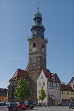 A sunny day with a clear blue sky over a historic tower of St John's Church in Lauf an der Pegnitz,