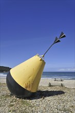 Big yellow buoy on beach at Brittany, France, Europe