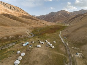 Aerial view, yurts in a mountain valley with a gravel road, Naryn region, Kyrgyzstan, Asia