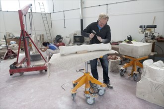 Sculptors working on local Portland stone in a community studio space on the Isle of Portland,