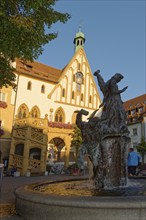 Wedding fountain in front of a bright town hall building under a clear sky, Amberg, Upper