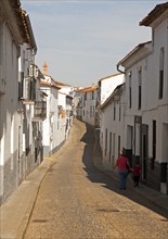 People walking along a quiet street in village of Jabugo, Sierra de Aracena, Huelva province,