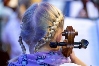 Young girl plays a cello at a concert