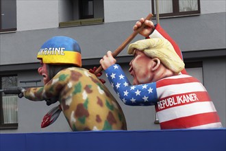 Donald Trump pierces a Ukrainian soldier with a spear, papier-mâché figure, satirical float by