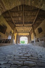 Interior view of a covered bridge with cobblestones and a wooden beam ceiling, Harz Mountains,