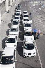 Line of white taxis queueing outside Malaga airport, Spain, Europe