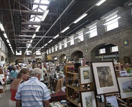 People browsing inside a traditional market place building at the Pannier Market, Tavistock, Devon,