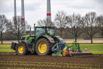 Tractor with a power harrow prepares the soil of a field for planting, Agriculture, Spring