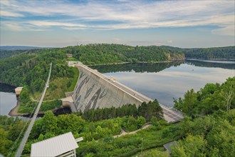 Wide panorama of a large dam next to a wide river, surrounded by forest and sky, Rappbodetalsperre,