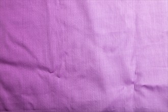 Fragment of smooth cotton purple tissue. Top view, flat lay, natural textile background and texture