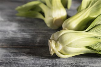 Fresh green bok choy or pac choi chinese cabbage on a gray wooden background. Hard light, contrast.