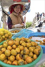 Vietnamese woman peeling khaki fruit at Heavens Gate, Ha Giang province, Vietnam, Asia