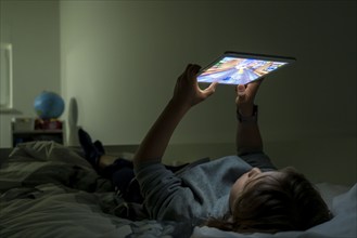 A boy plays computer games on a tablet PC