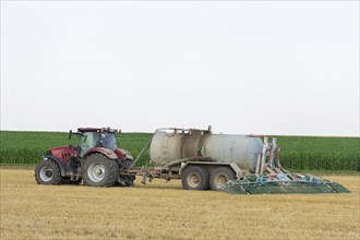 Farmer spreading liquid manure on harvested grain field, Swabian Alb, Baden-Württemberg, Germany,