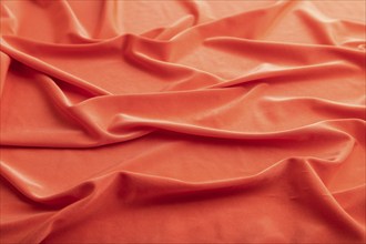 Fragment of red silk tissue. Side view, natural textile background and texture. wave concept,