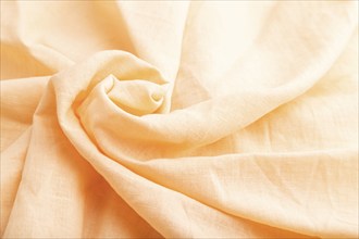 Fragment of orange linen tissue. Side view, natural textile background and texture. wave concept,