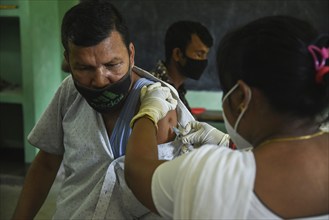 Beneficiaries receives dose of COVID-19 coronavirus vaccine in a vaccination centre at a village in