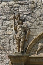 Stone figures, statue, male warrior above portal, detail, armour, weapons, decoration,