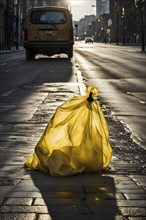 Plastic garbage bag abandoned of a desolate empty city street, AI generated