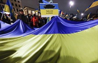 People demonstrate with a huge Ukrainian flag at the Brandenburg Gate on the anniversary of the